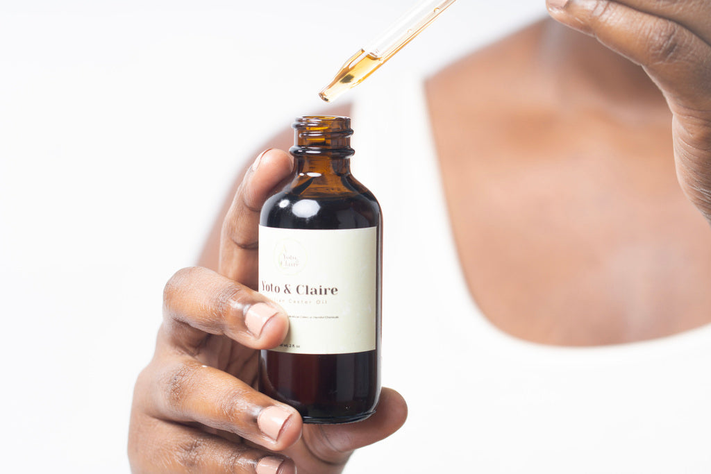 Model Holding Haitian Black Castor Oil Dropper