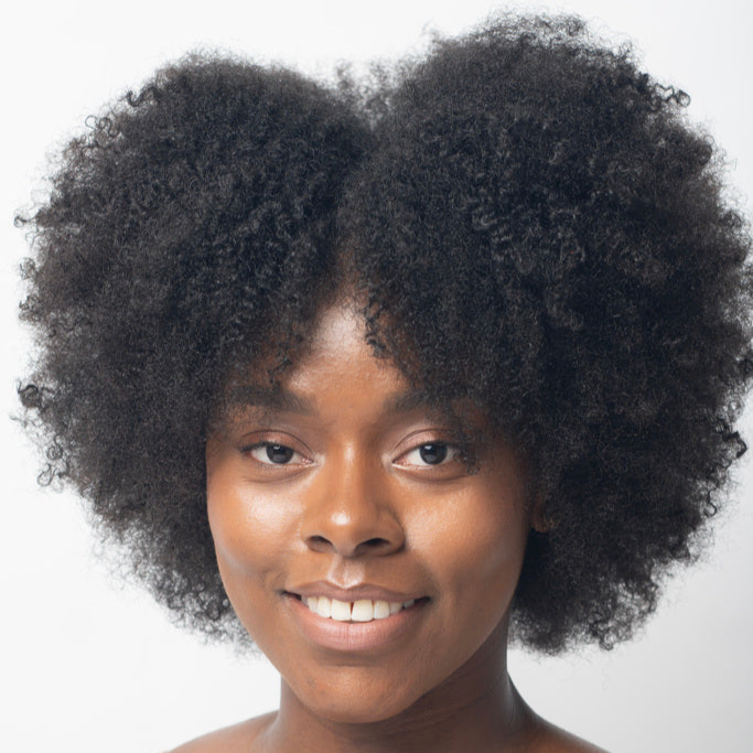 Woman with textured afro hair smiling